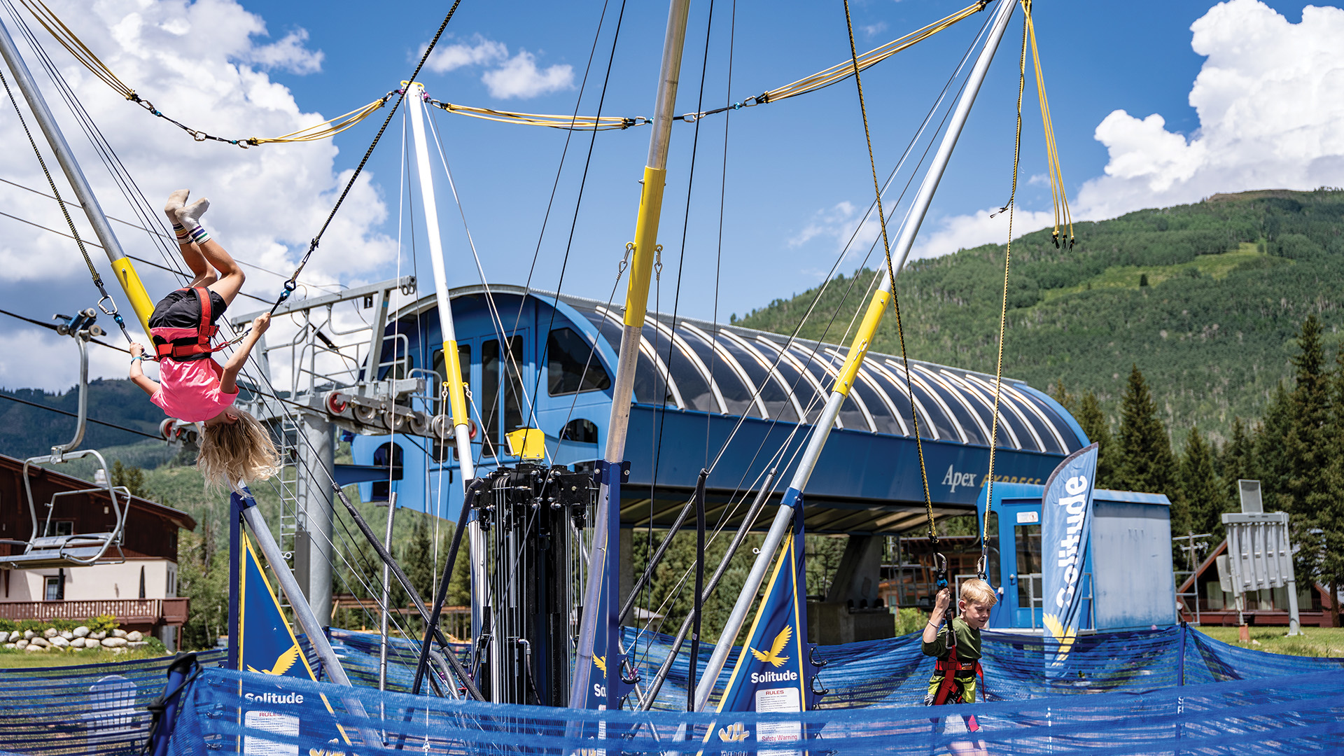 Kids flipping on the bungee trampoline at the Adventure Park at Solitude