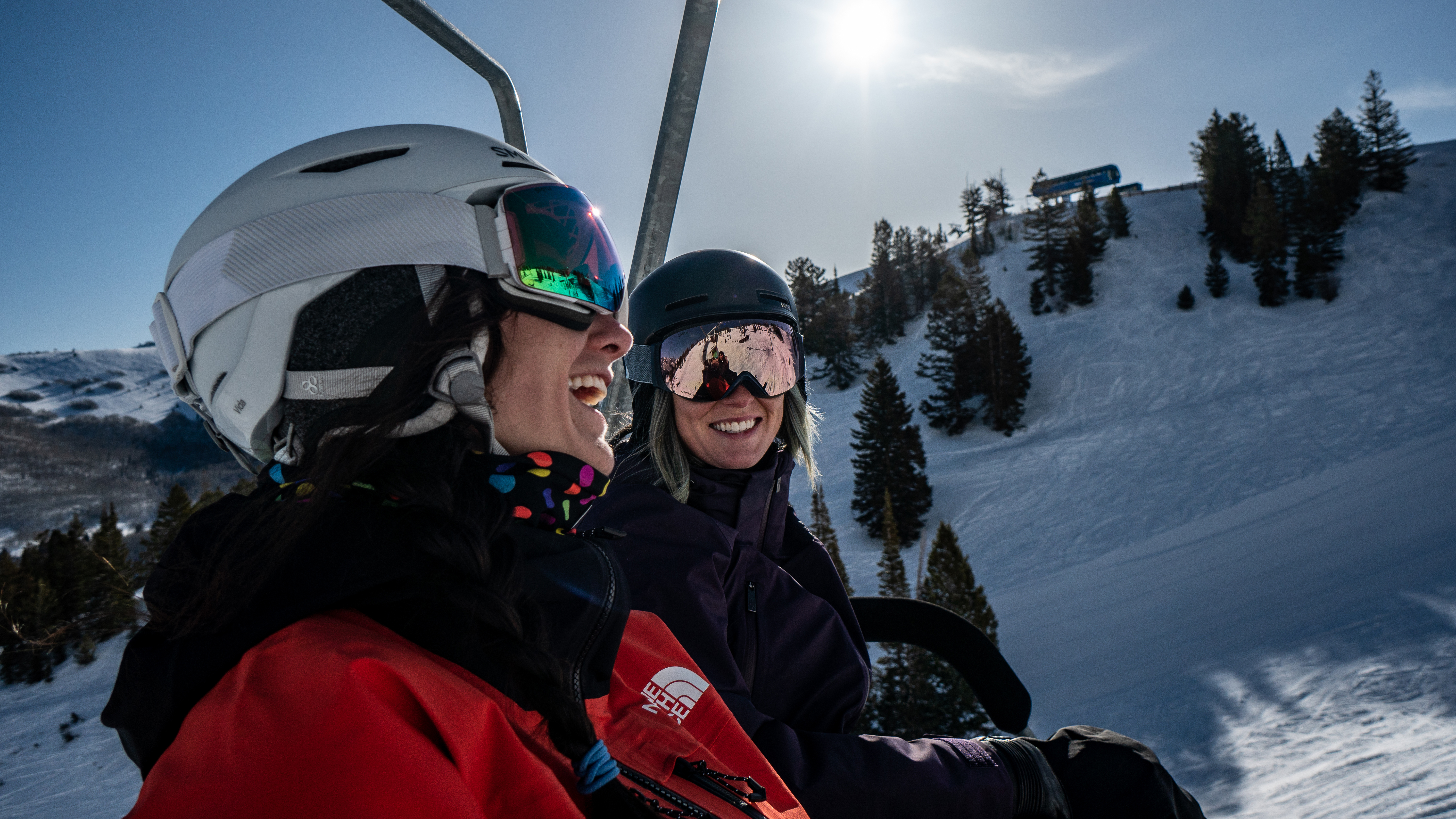 Two friends on the chairlift laughing and having a good time