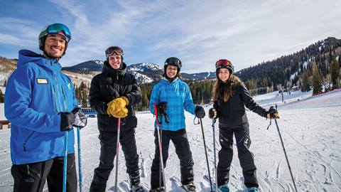 Three friends taking a ski lesson. 