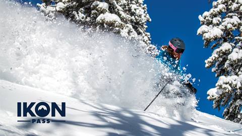 Person skiing pow with Ikon Pass logo overlayed