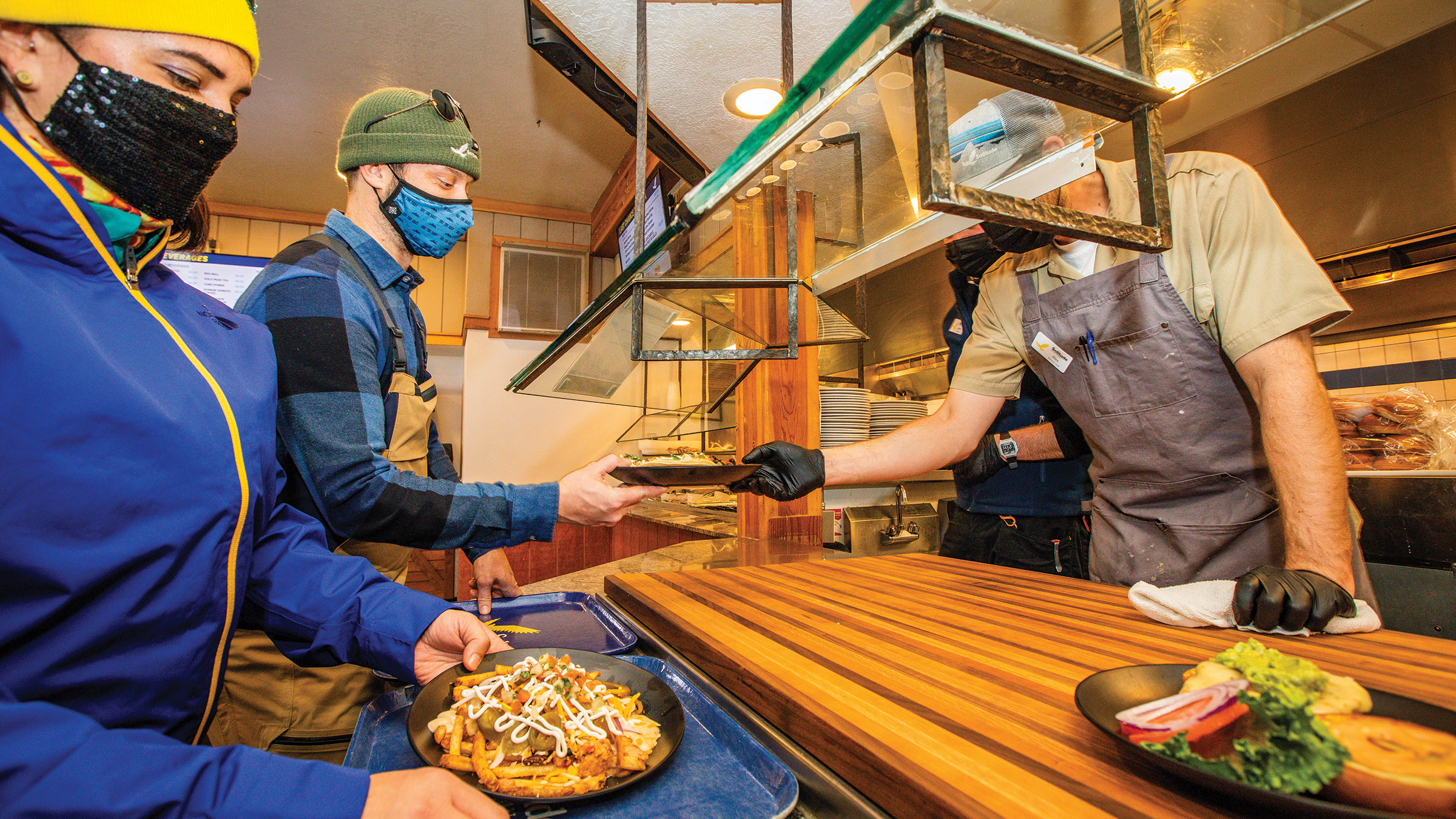 Two people getting lunch handed to them by server at Last Chance Lodge