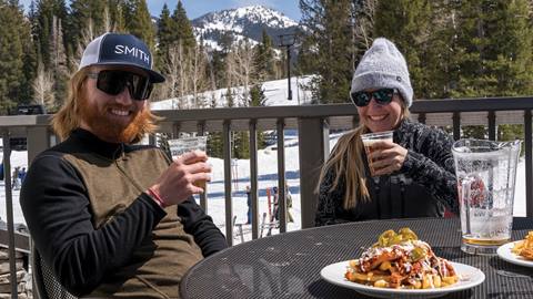 Friends enjoying drinks and nachos on the Moonbeam Lodge rooftop. 