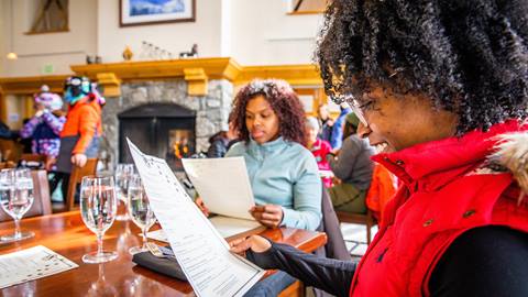 Two friends looking at the menu at St. Bernard's at Solitude Mountain Resort