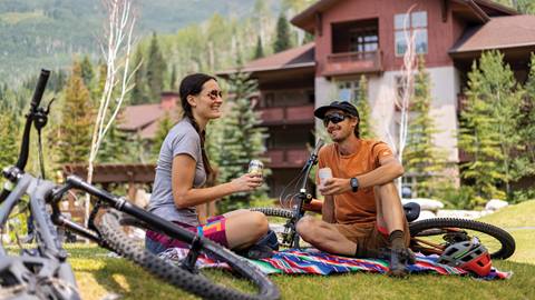 A couple drinking beer outside Stone Haus after mountain biking