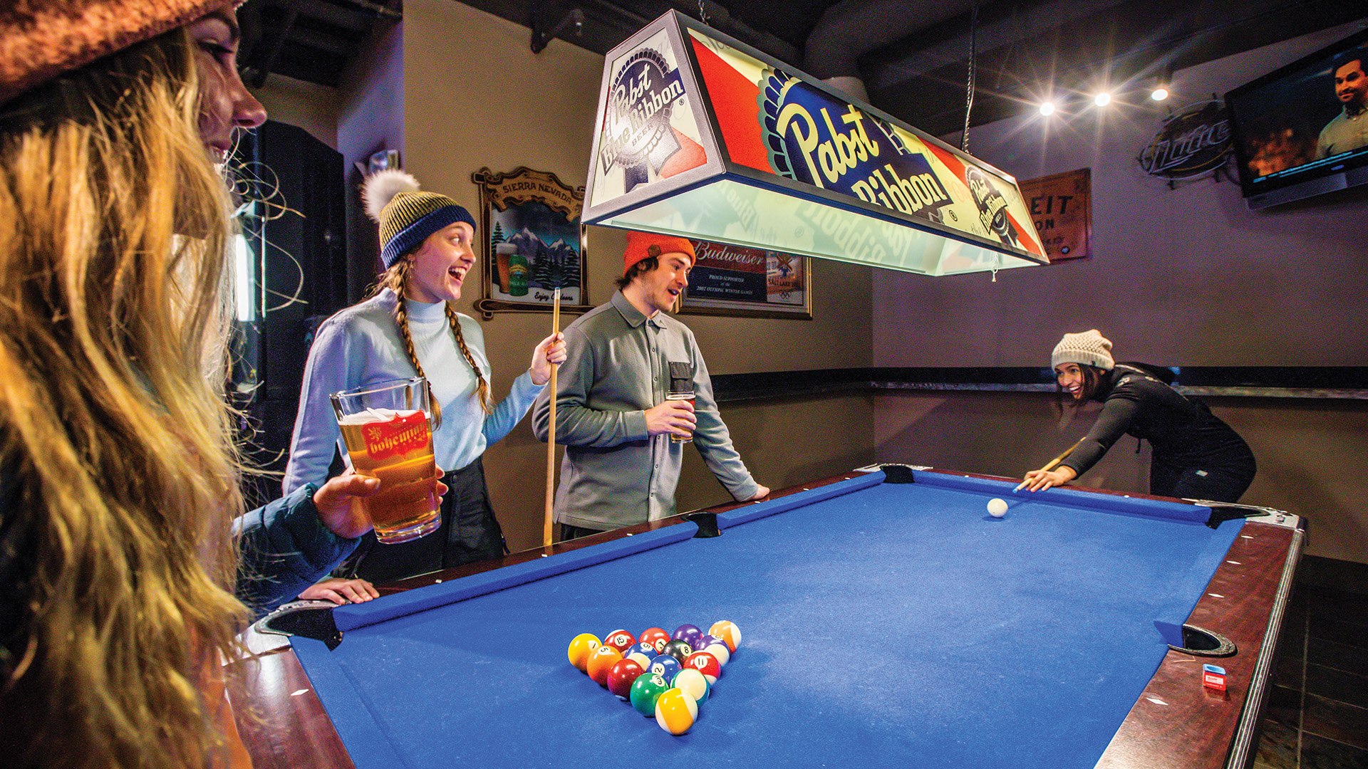 Friends playing pool at The Thirsty Squirrel
