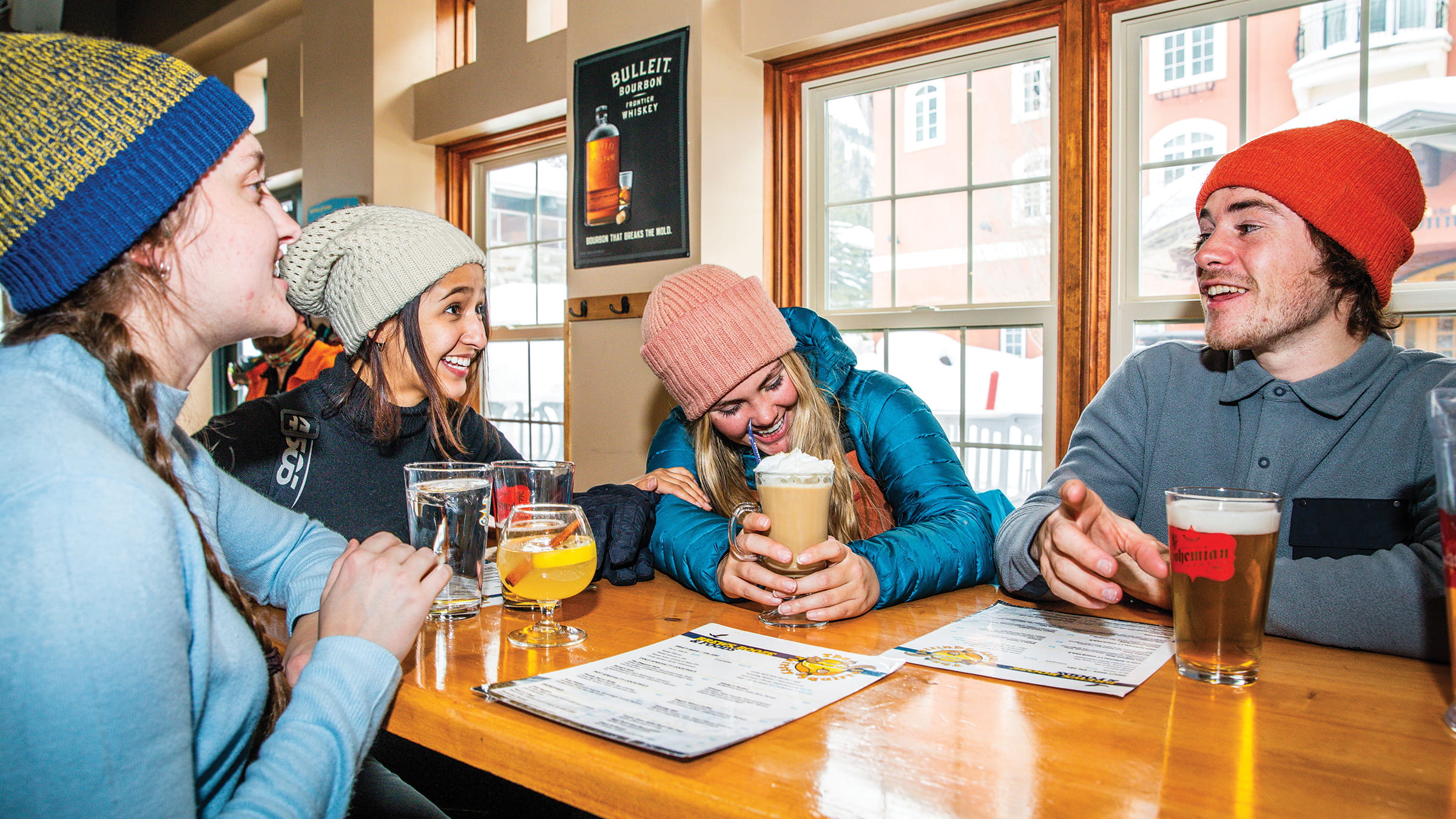 Friends laughing over drinks at The Thirsty Squirrel