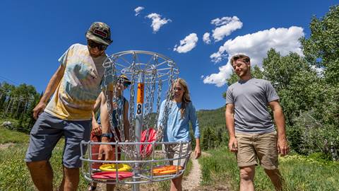 Friends collecting their discs after finishing a hole of disc golf at Solitude Mountain Resort