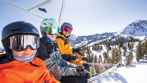 Three skiers riding a chairlift at Solitude