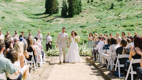 newly married couple walking down the aisle outdoors with mountain views at a wedding venue at solitude mountain resort