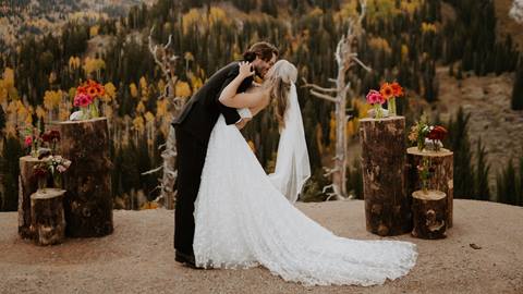 wedding couple kissing at an outdoor altar with floral decor at a wedding venue at solitude mountain resort