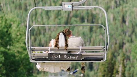 just married couple riding a scenic chairlift together at a wedding venue at solitude mountain resort