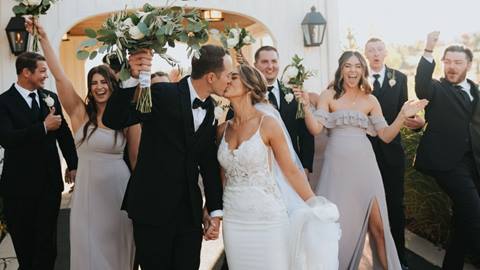 wedding party celebrating as the bride and groom kiss at an outdoor wedding venue at solitude mountain resort