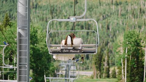 A bride and groom ride the chairlift at Solitude Mountain Resort