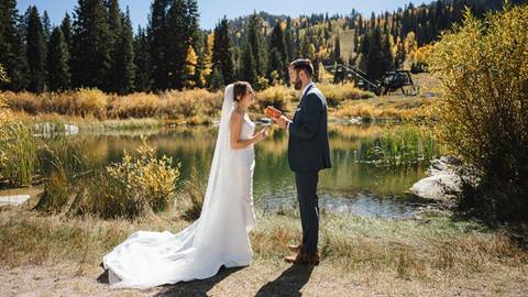 A couple exchanges wedding vows in a scenic mountain landscape at Solitude Mountain Resort