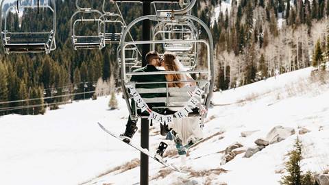 Newlyweds rides the chairlift during a winter wedding at Solitude Mountain Resort