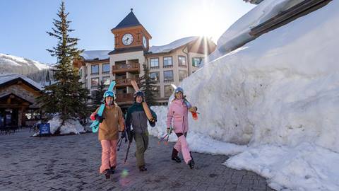 Three friends walking through the Village at Solitude Mountain Resort on their way to go skiing