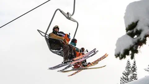 Four friends sitting on a chairlift at Solitude Mountain Resort