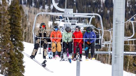 Skiers and snowboarders ride the Eagle Express six-pack chairlift at Solitude Mountain Resort