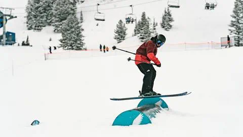 A skier riding a park feature in the Main Street Terrain Park at Solitude Mountain Resort
