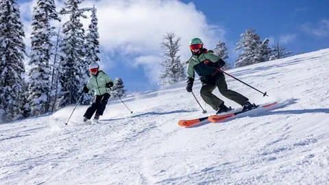Two sisters skiing next to each other at Solitude Mountain Resort