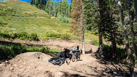 Two friends riding a berm section at Solitude Bike Park