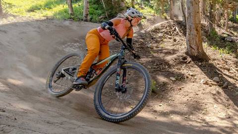 A mountain biker banks at turn at Solitude Bike Park