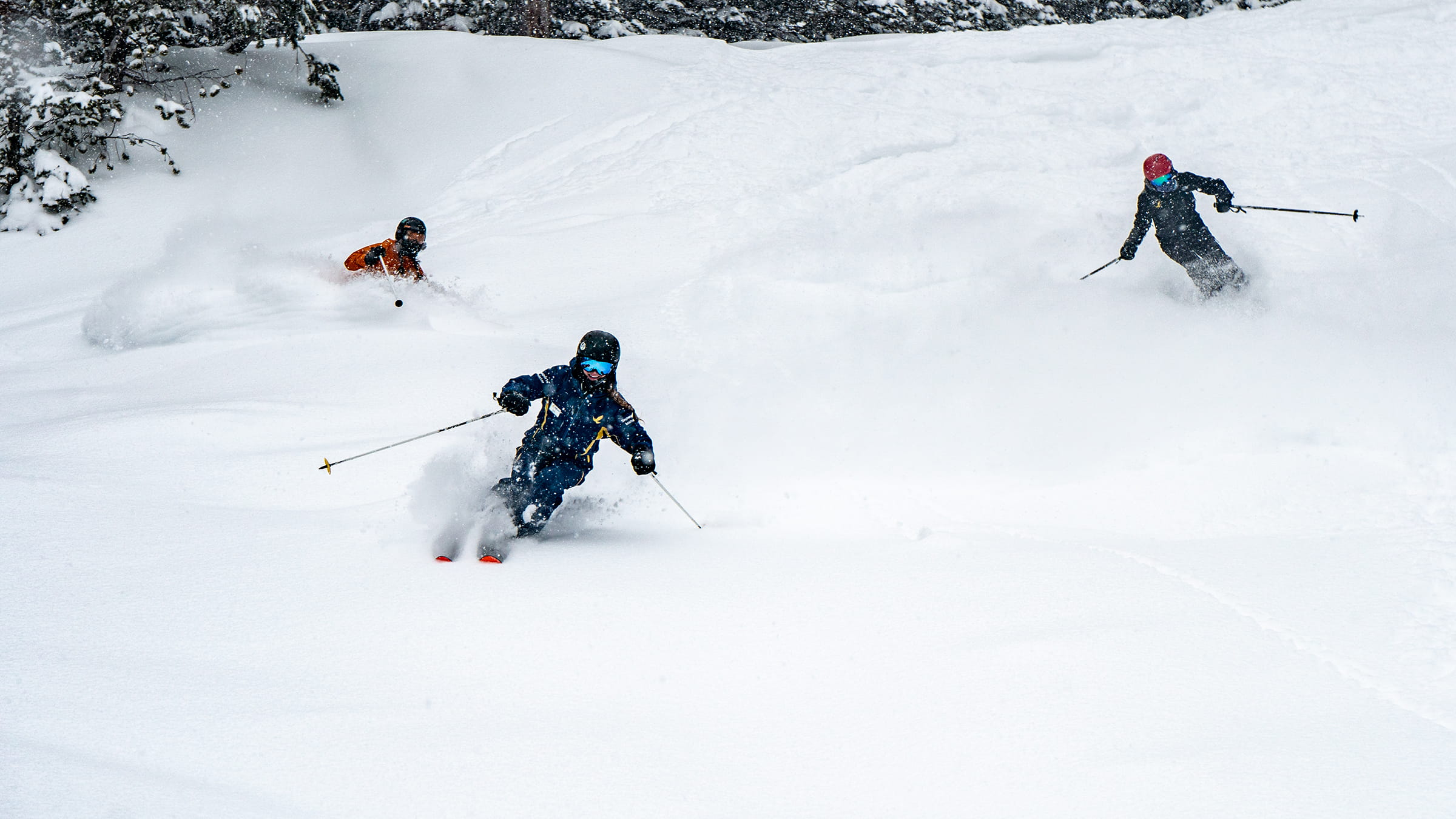 Big Mountain Coach guides two skiers on the big mountain team through fun and deep powder
