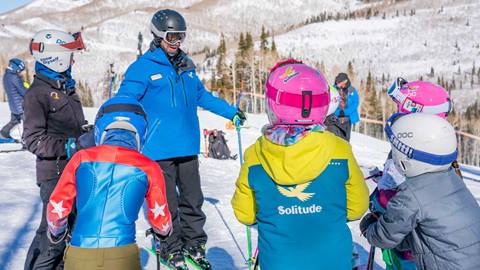 An instructor talks with young skiers on the Solitude Mountain Resort Race Team