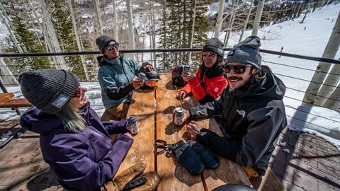 Friends enjoy beers on the patio of Roundhouse at Solitude Mountain Resort