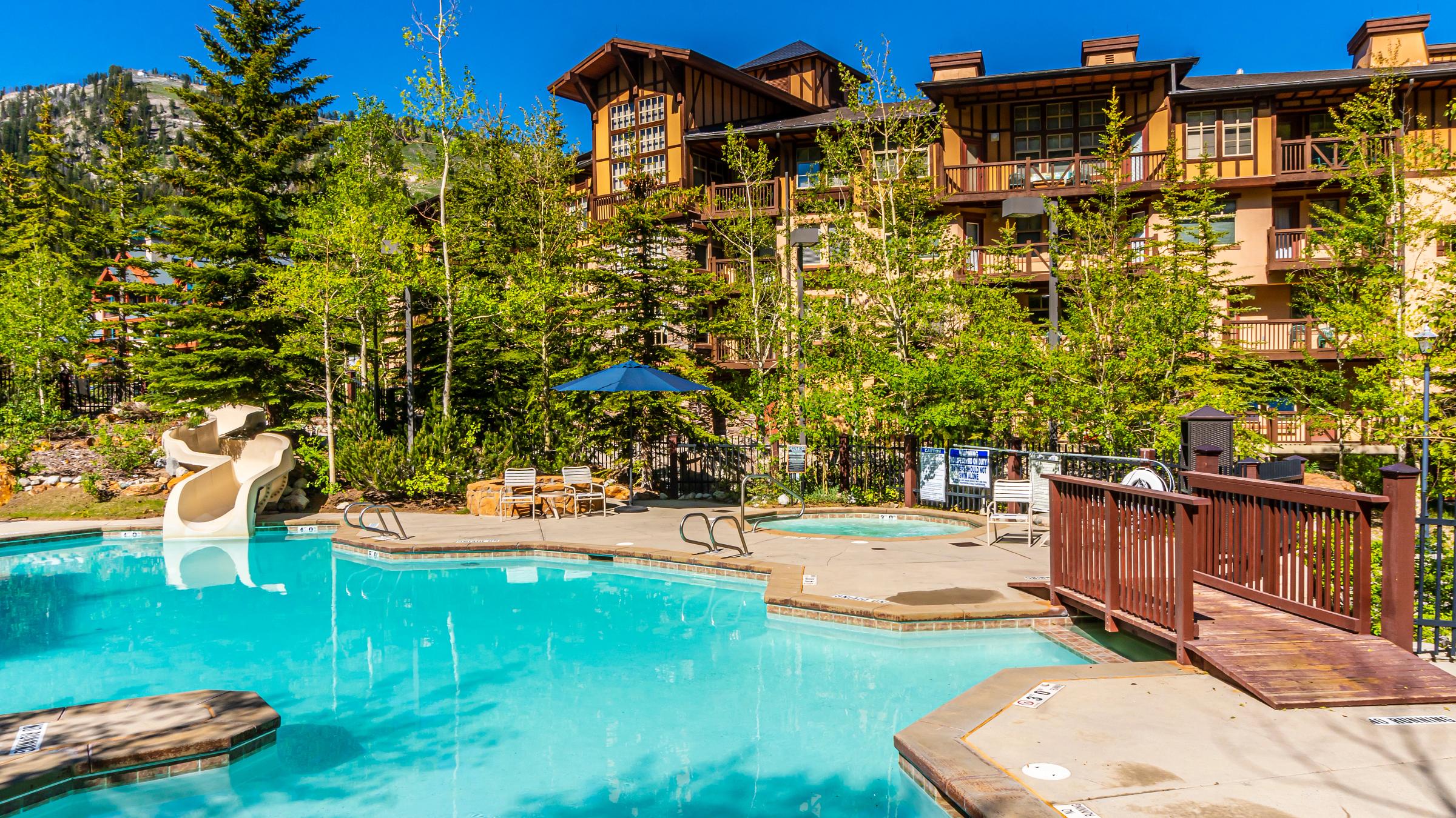 Outdoor pool, hot tub, and water slide at Solitude Mountain Resort