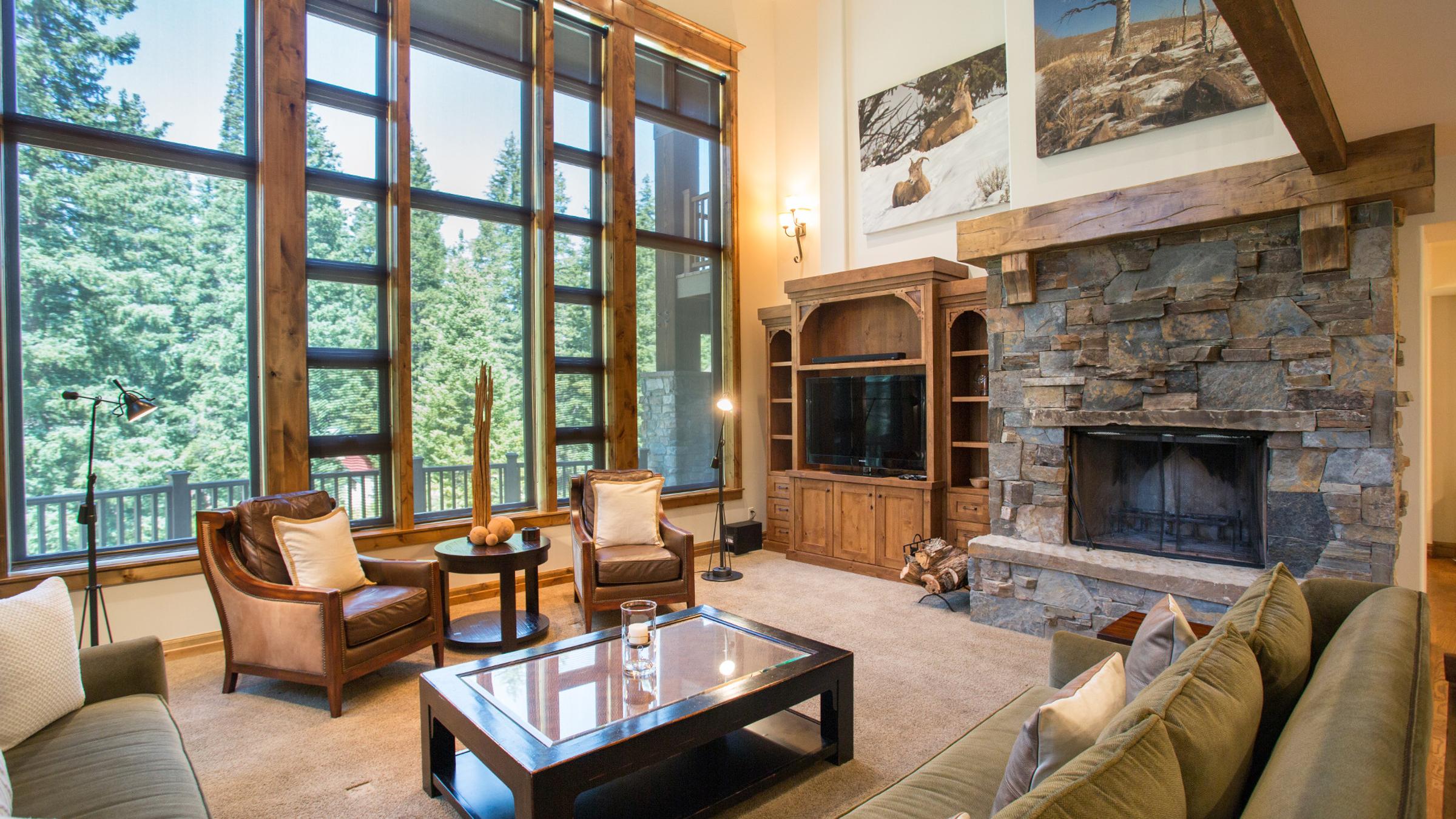 Living room with couches and chairs, fireplace, tv and large windows