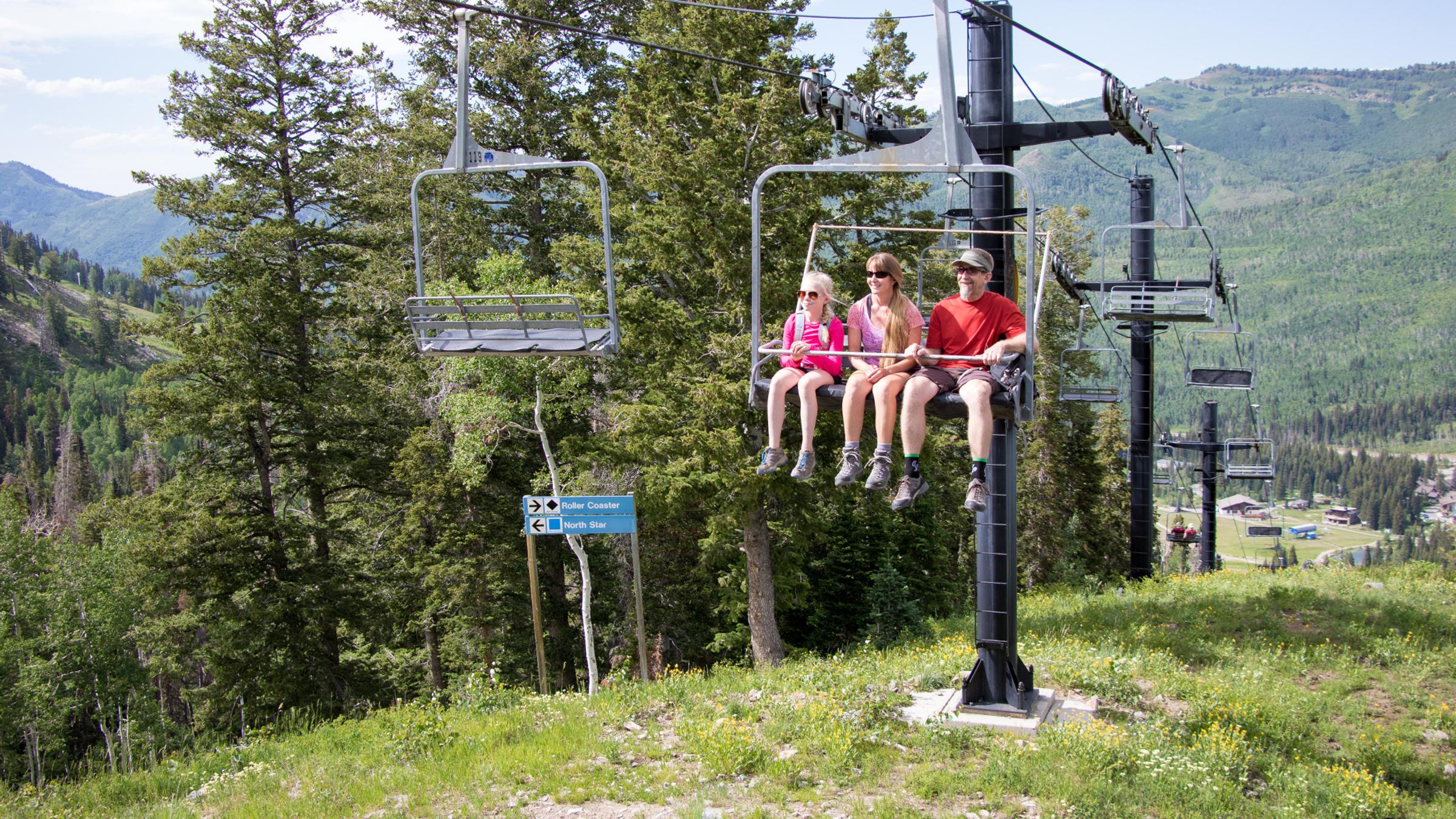 Family riding the chairlift in the summer