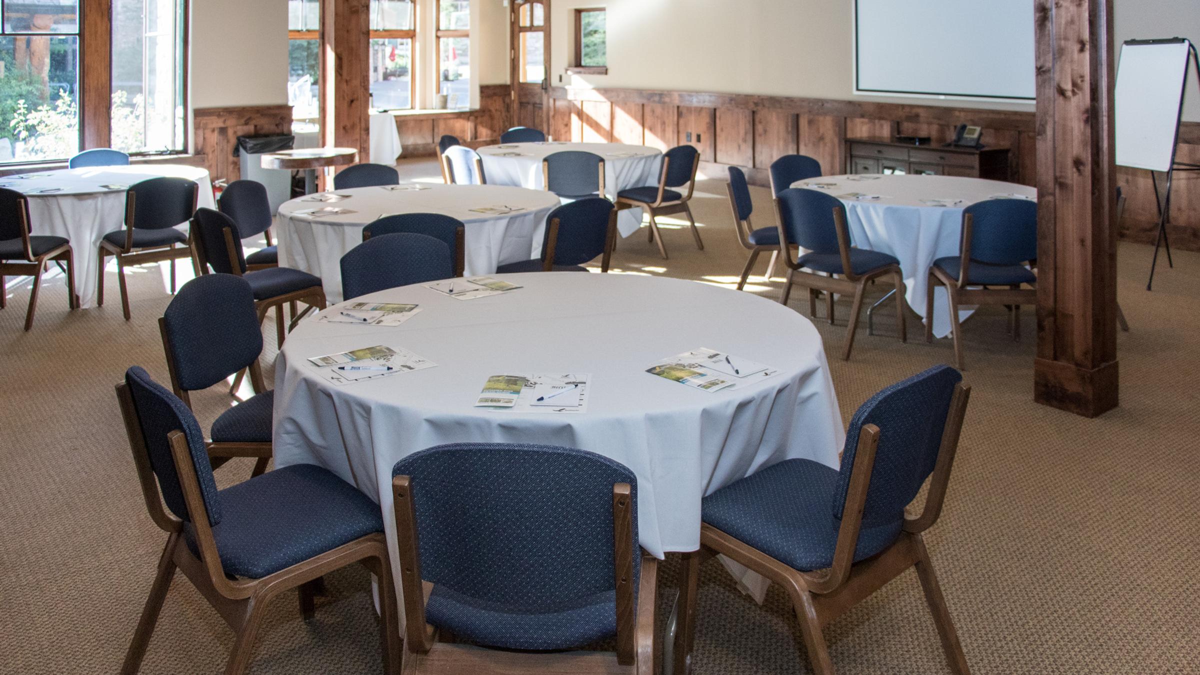 Creekside Meeting Space set up with round tables for a presentation