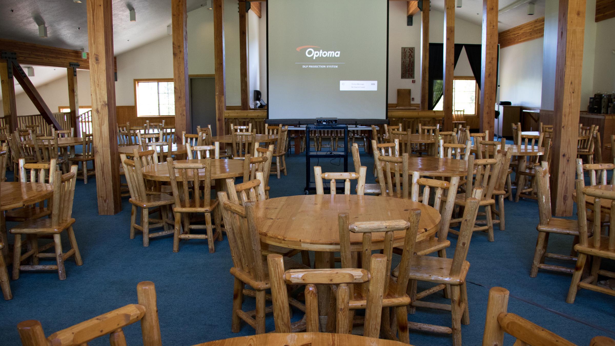 Meeting space in Last Chance Lodge with round wooden tables and chairs setup