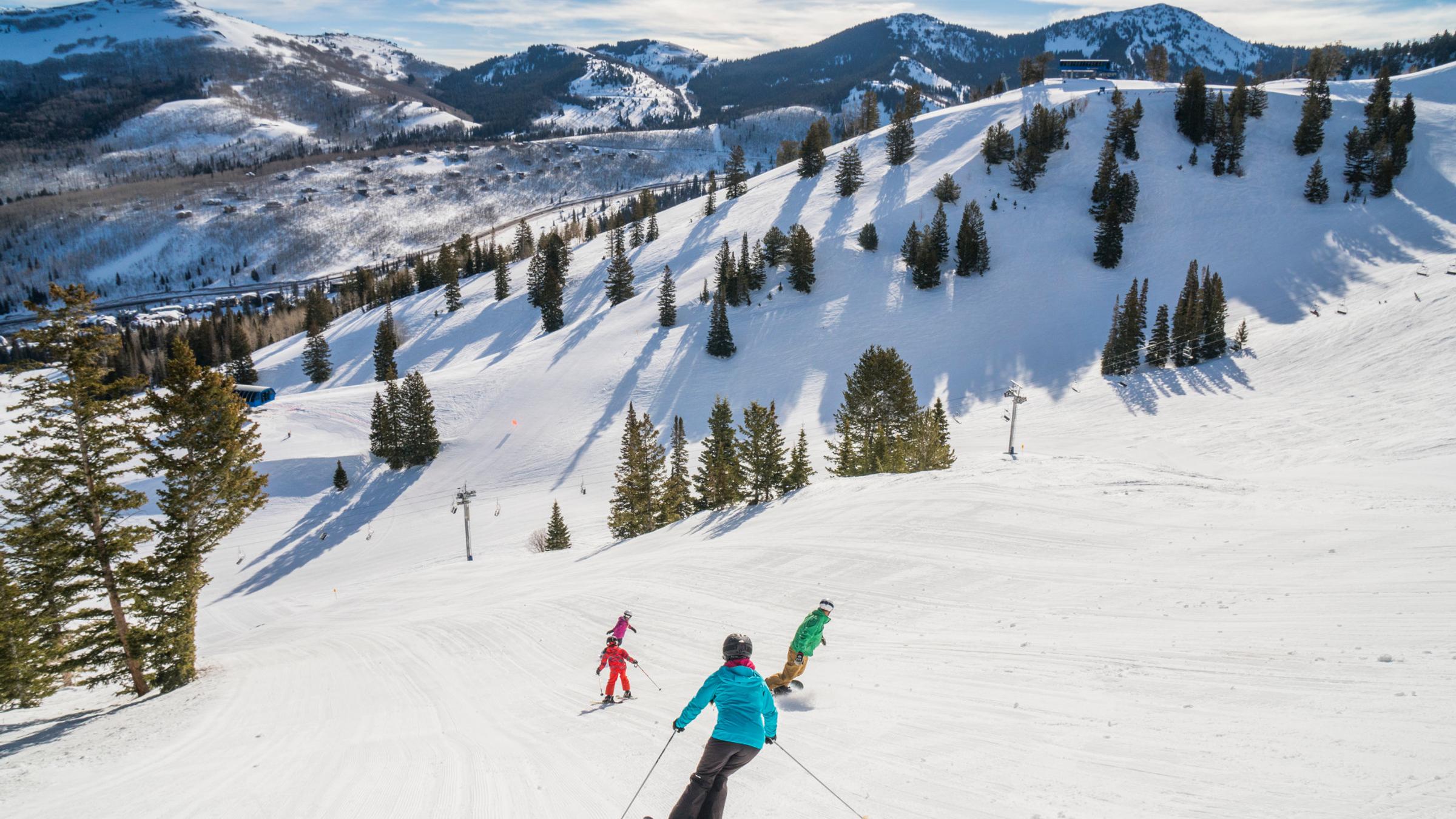 Family skiing and snowboarding together