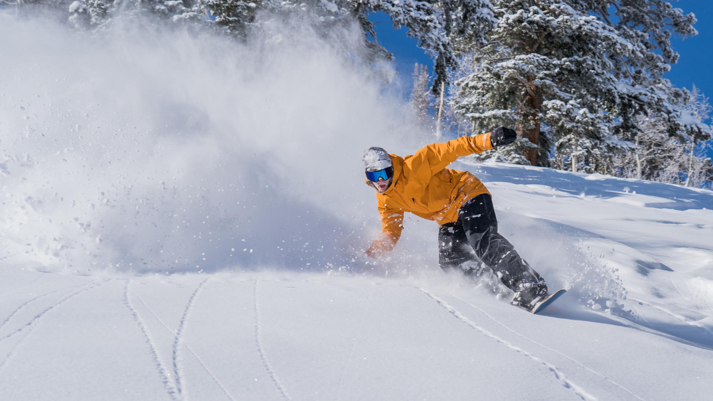 Solitude Athlete James Fleege snowboarding on a bluebird powder day at Solitude