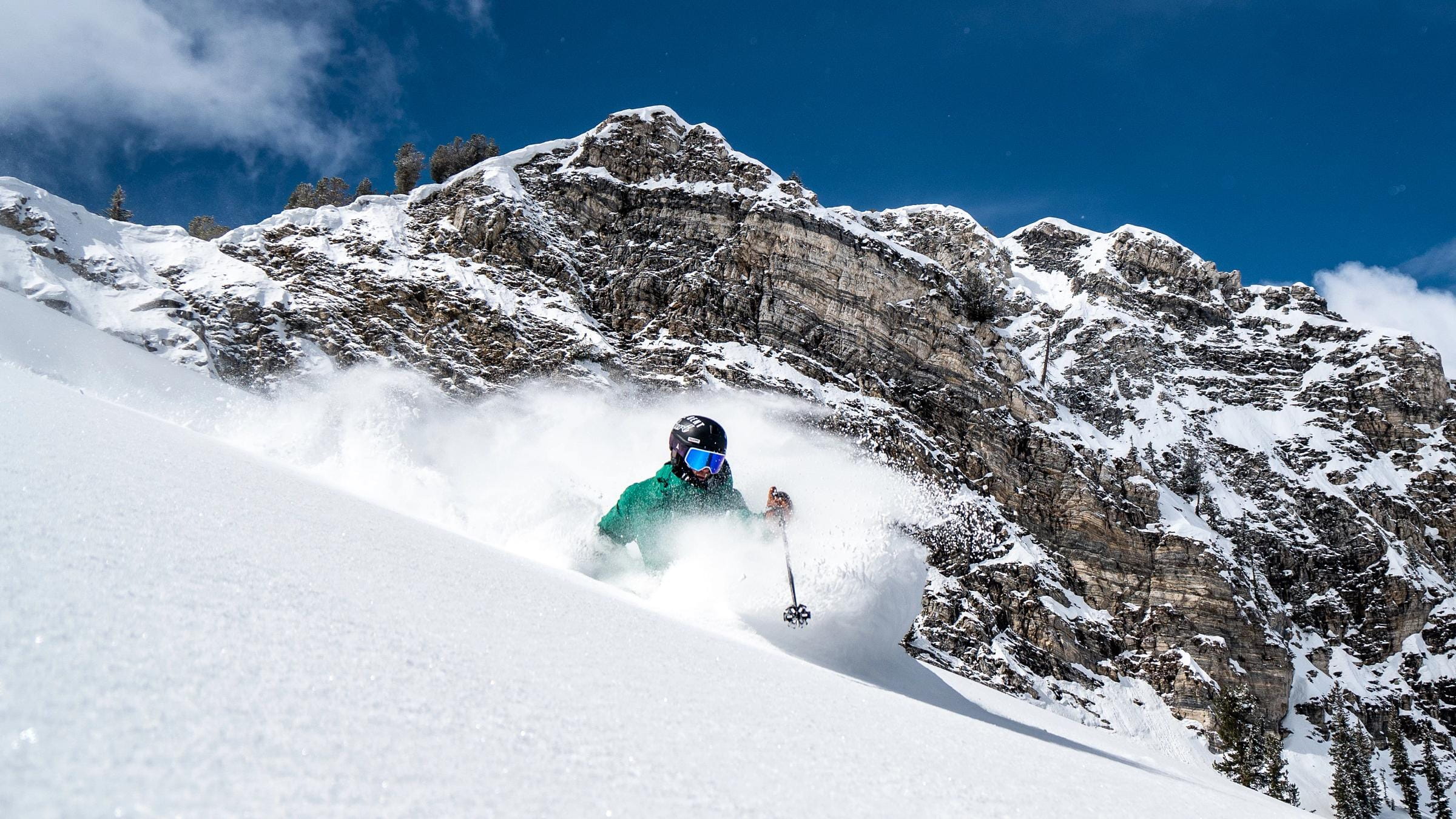 A male skier makes a powder turn in Honeycomb Canyon at Solitude Mountain Resort