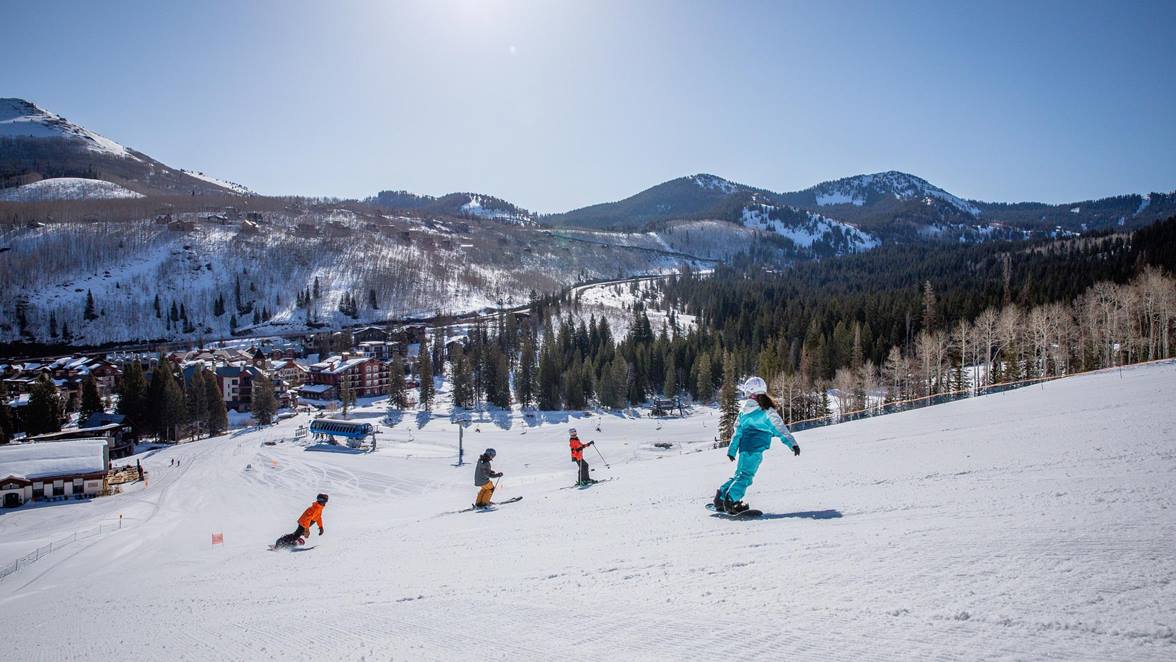 A family skiing and snowboarding together at Solitude Mountain Resort